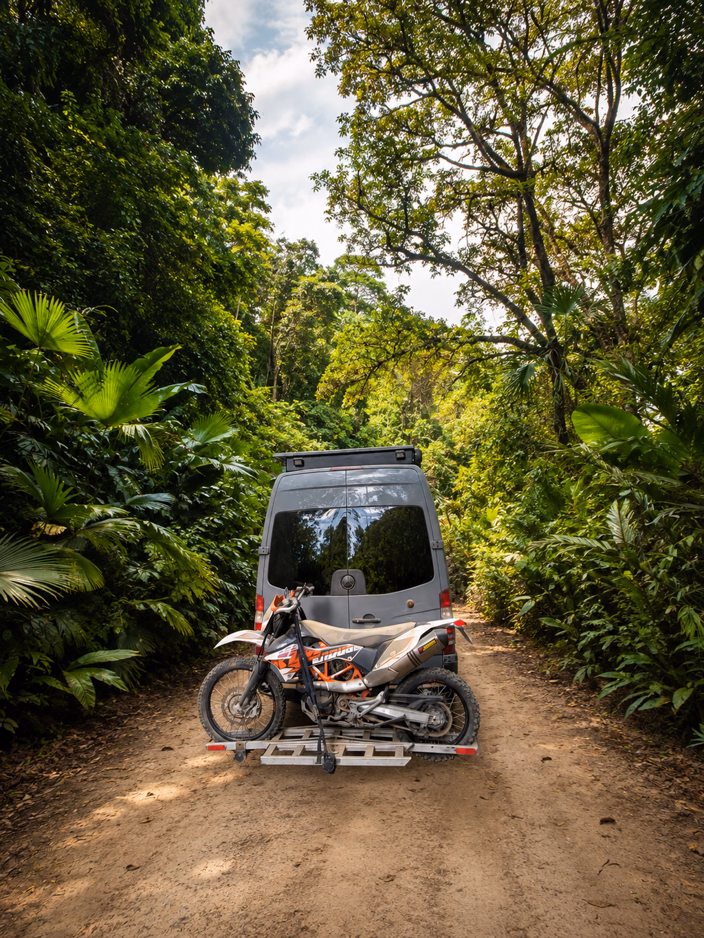 Fourgon et moto sur un chemin exigeant au cœur de la jungle.